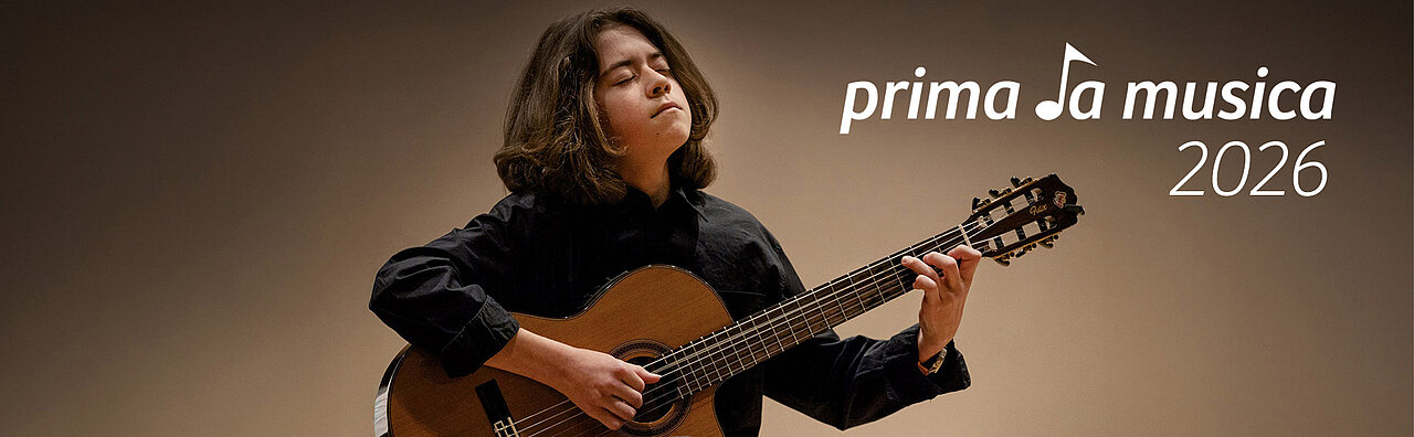 Jugendlicher mit langen Haaren spielt akustische Gitarre